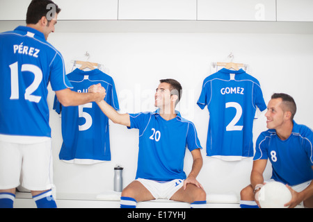 Fußball-Spieler Händeschütteln in Umkleidekabine Stockfoto