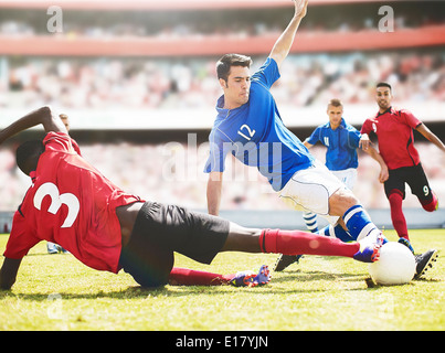 Fußball-Spieler treten Ball auf Feld Stockfoto