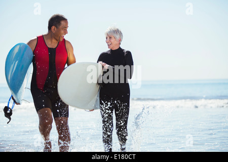 Älteres Paar mit Surfbrettern am Strand Stockfoto