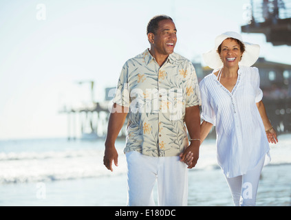 Paar Hände halten und zu Fuß am Strand. Stockfoto
