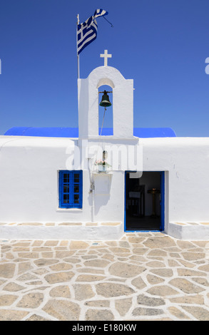 Griechische weiße Kirche mit der Flagge von Griechenland über den Glockenturm, Paros, Griechenland Stockfoto