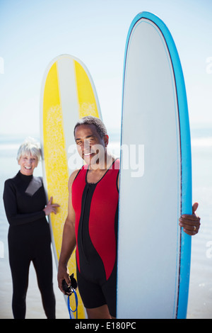 Porträt von älteres Paar mit Surfbrettern Stockfoto