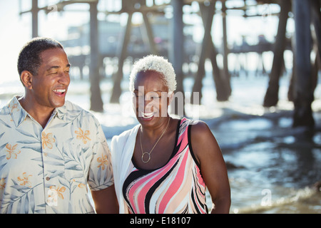 Älteres Paar am Strand in der Nähe von pier Stockfoto