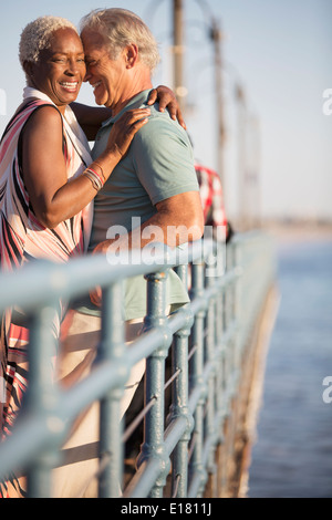 Älteres paar umarmt am pier Stockfoto