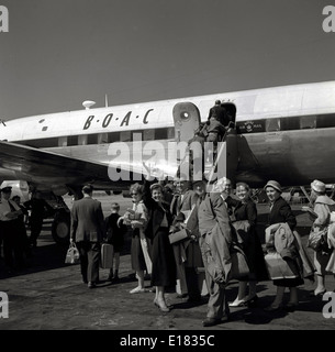 1960er Jahre historische Bild zeigt eine Gruppe von Passagieren ein B.O.A.C Flugzeug auf der Landebahn am Flughafen London. Stockfoto