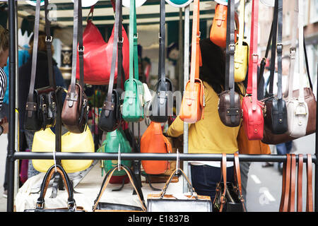 London Straße Markt: Soho-Flohmarkt, Dean Street, London, UK.  Ein geschäftiger Markt mit Touristen und Einheimischen. Bunte Handtaschen auf einem Marktstand angezeigt. Stadtmärkte Showcase. Stockfoto