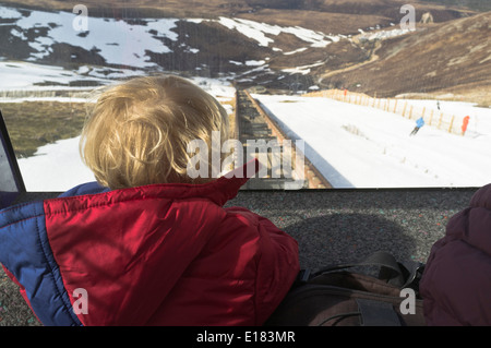 Dh Cairngorm National Park AVIEMORE INVERNESSSHIRE kind Blick aus der Seilbahn am Bahnhof Anschluss Skifahrer Schottland Schnee Stockfoto