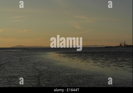 Orange Wolkenfetzen Sonnenuntergang vom Sandstrand Küste bei St. Annes gegen Blackpool und Cumbrian Mountains, Fylde Küste Stockfoto