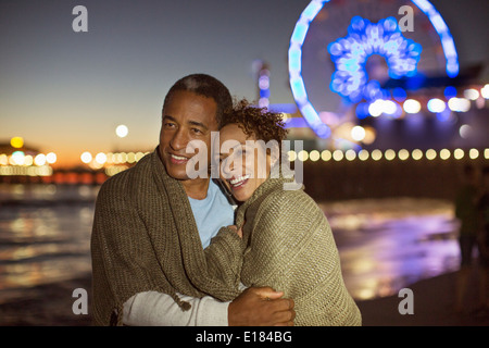 Paar am Strand in der Nacht umarmt Stockfoto
