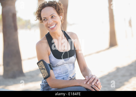 Lächelnde Frau in Sportkleidung tragen Armband Stockfoto