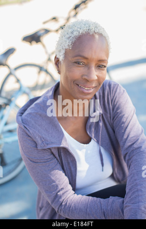Porträt der lächelnde Frau in der Nähe von Fahrrad Stockfoto