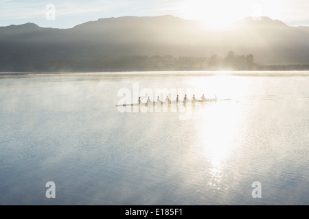 Team-Ruderboot auf noch See rudern Stockfoto