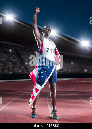 Leichtathletin und Olympiateilnehmerin eingewickelt in amerikanische Flagge auf dem richtigen Weg Stockfoto