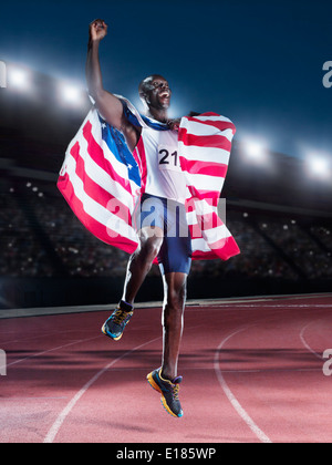 Läufer, die amerikanische Flagge und feiern auf dem richtigen Weg