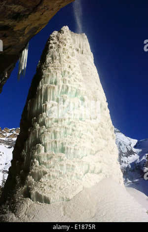 Eis-Säule unter Wasserfall am Oeschinensees See, Bluemlisalphorn auf der Rückseite. Kandersteg, Berner Alpen, Schweiz Stockfoto