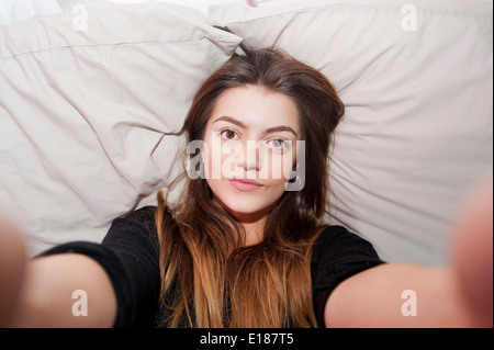 13 Jahre alten Mädchens posieren für ein vorgeben Selfie in ihrem Schlafzimmer Stockfoto