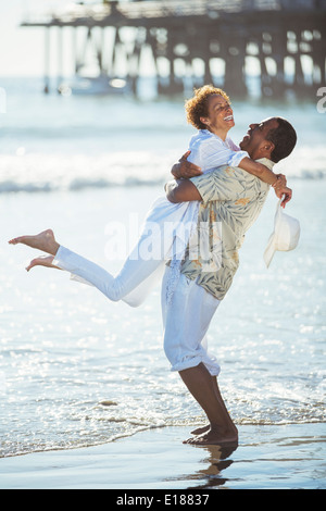 Paar am Strand umarmt Stockfoto