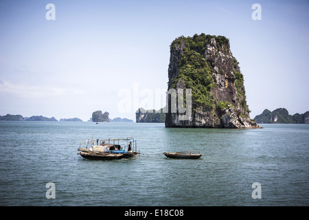 Ein Fischerboot navigiert zwischen den kleinen Inseln der Ha Long Bay Stockfoto