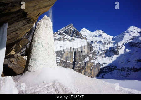 Eis-Säule unter Wasserfall am Oeschinensees See, Bluemlisalphorn auf der Rückseite. Kandersteg, Berner Alsp, Schweiz Stockfoto