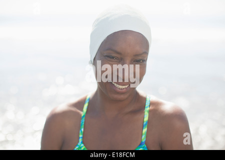 Porträt der lächelnde Frau in Badekappe am Strand Stockfoto