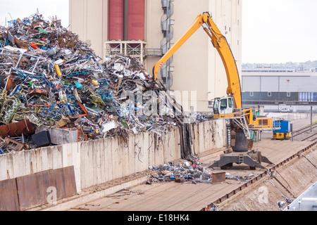 Offenen Schiff geladen oder in einem Kai auf einem städtischen Wasserstraße oder Fluss durch ein heavy-Duty Industriekran abgeladen Stockfoto