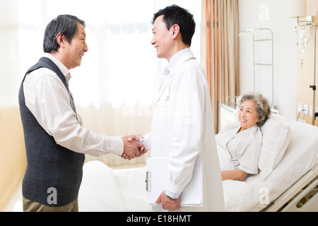 Älteres paar Händeschütteln mit Arzt im Krankenhaus Stockfoto