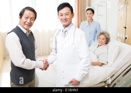 Älteres paar Händeschütteln mit Arzt im Krankenhaus Stockfoto
