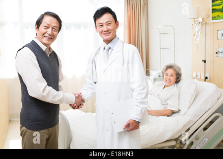 Älteres paar Händeschütteln mit Arzt im Krankenhaus Stockfoto