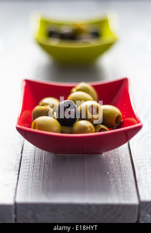 Bunte Obst Oliven in Schalen auf Holztisch Stockfoto