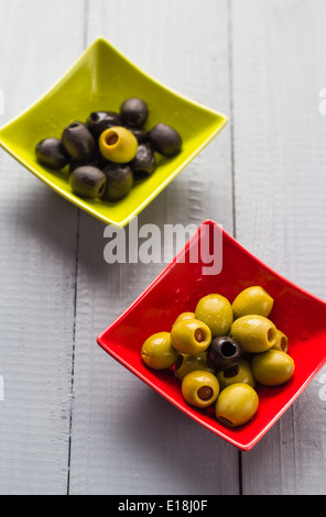 Bunte Obst Oliven in Schalen auf Holztisch Stockfoto