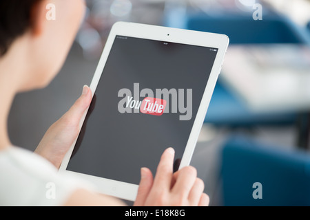 Frau hält ein nagelneues Apple iPad Air mit YouTube-Logo auf einem Bildschirm Stockfoto