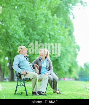 Älteres Paar auf Bank im Park sitzen im Gespräch Stockfoto