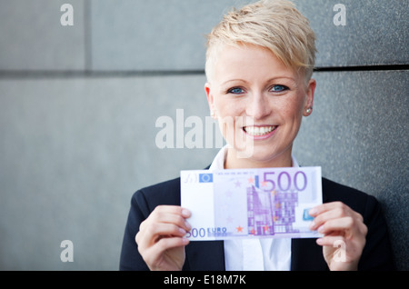 Attraktive Geschäftsfrau hält 500 euro Stockfoto