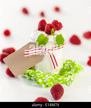 Frische reife Himbeeren serviert mit einem Glas des gesunden Joghurt oder Clotted Cream für ein leckeres Dessert oder Frühstück mit copysp Stockfoto