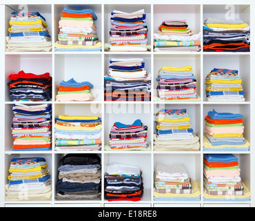 Handtücher, Bettwäsche und Kleidung auf dem Regal Stockfoto