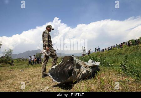 Srinagar, Kaschmir Indien kontrollierten. 27. Mai 2014. Ein Soldat der indischen Luftwaffe (IAF) prüft die Trümmer einer IAF Kampfjet im Dorf Marhama-Bijbehara, etwa 50 km südlich von Srinagar Stadt, die Sommer-Hauptstadt von Indien kontrollierten Kaschmir, 27. Mai 2014. Der Chief Minister von Indien kontrollierten Kaschmir Omar Abdullah Dienstag ausgedrückt Beileid über die Ermordung eines IAF Piloten in einer MiG-21-Jet abstürzen. Bildnachweis: Javed Dar/Xinhua/Alamy Live-Nachrichten Stockfoto