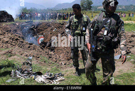 Srinagar, indische verabreicht Kaschmir. 27. Mai 2014: indische Armeesoldaten stehen in der Nähe von den Trümmern der MiG - 21 Kampfflugzeugen der indischen Luftwaffe die stürzte auf Marhama Bijbehara Dorf im Anatnag Bezirk, südlich von Srinagar rund 45 Kilometer (28miles) entsprechend Nachrichtenreport der Pilot wurde getötet andere verletzte bei Crash ein Court Of Inquiry bestellt wurde, um über die Ursachen des Unfalls zu untersuchen. Bildnachweis: Sofi Suhail/Alamy Live-Nachrichten) Stockfoto