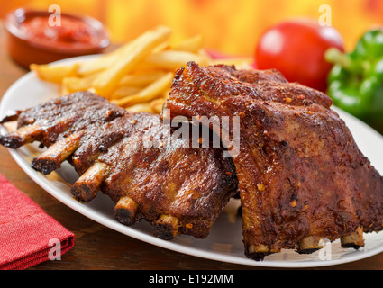 Gegrilltes Schweinefleisch Baby zurück ribs Hintergrund Feuer Hartholz. Stockfoto