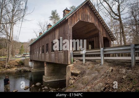 Ein Mann fischt auf Little Pigeon River, durch die Emerts Cove überdachte Brücke in Pittman Center, Tennessee Stockfoto