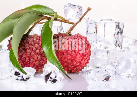 frischen Litschi mit grünen Blättern und Eiswürfel auf dem weißen Hintergrund Stockfoto