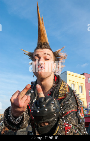 Punk mit stacheligen Mohican Haar Umdrehen der Finger, Camden Town, London, UK Stockfoto