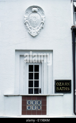 Eine Zierkartusche liegt über einer ehemaligen Eingangstür zu den alten 1922 Ozark Bädern auf historischen Bathhouse Row in Hot Springs, Arkansas, USA. Stockfoto