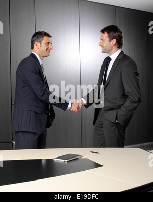 Ernsthafte Geschäftsleute, schütteln ihre Hände nach einem Treffen im Büro Stockfoto