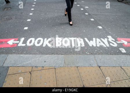 Schauen Sie Both Ways Zeichen auf der Straße am Fußgängerüberweg, England, UK Stockfoto