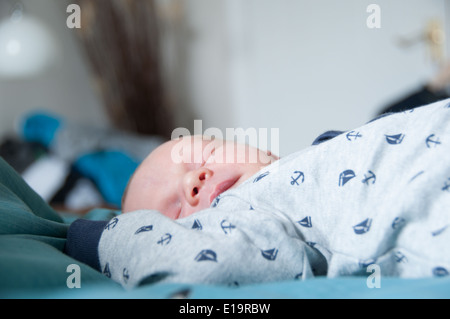 Baby schläft auf einer weichen Decke mit Armen über dem Kopf Stockfoto