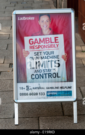 Ein verantwortungsvoll spielen Zeichen außerhalb einer Ladbrokes Wetten Shop beraten Menschen setzen Ihre eigenen Maschine Grenzen und Aufenthalt in der Steuerung. Stockfoto