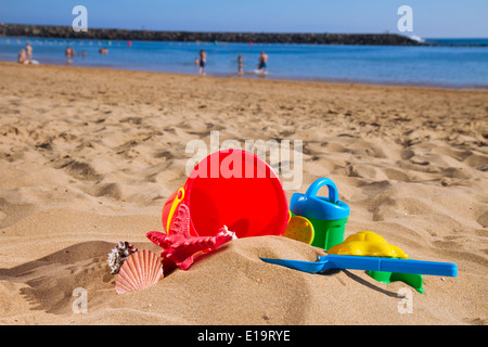 Eimer mit Kunststoff Strandspielzeug im Sand am Meer Stockfoto