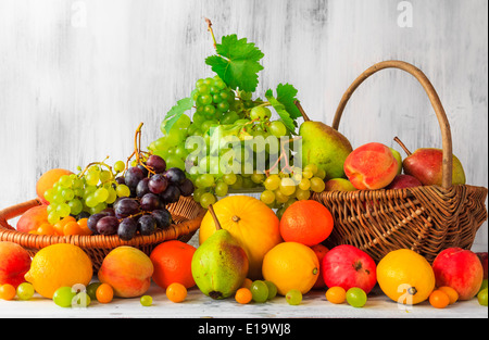 Frisches Obst in Körben voller Holztisch Stockfoto