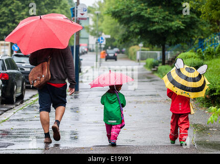 Berlin, Deutschland. 28. Mai 2014. Ein Vater und seine Kinder halten Sonnenschirme bei Regen in Berlin, Deutschland, 28. Mai 2014. Foto: Hauke-Christian Dittrich/Dpa/Alamy Live News Stockfoto