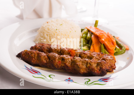 Türkische Adana Kebap Reis-Pilaw mit Gemüse auf einem Teller serviert Stockfoto